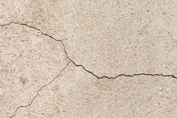 Cracked beige wall texture. Yellow sand stone with a crack