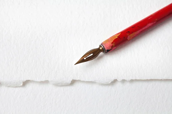 Red nib fountain pen on white paper textured background. macro view shallow depth of field, copy space