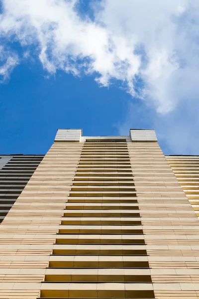 High-rise building modern architecture. Looking up blue sky white clouds, daylight urban landscape background, bottom view