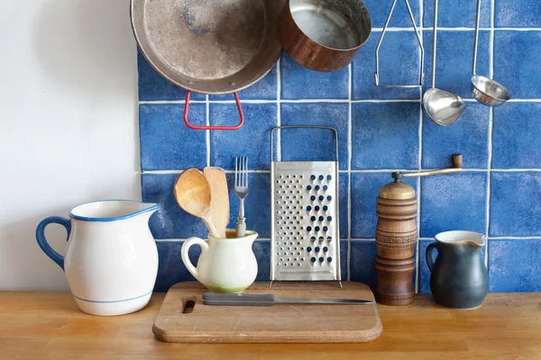 Kitchen interior accessories. pots jug pan cutting board, wooden spoon, cooper ladle stewpan.