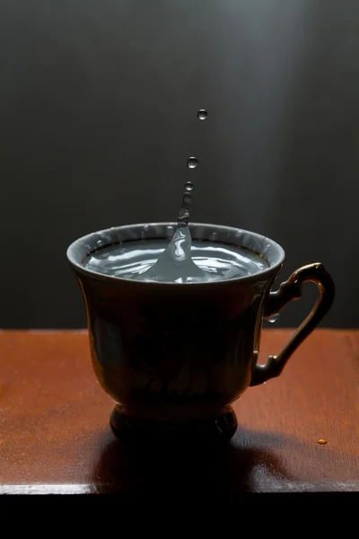 Water drops, splashing in cup