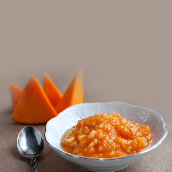 Pumpkin porridge, slices organic orange pumpkin, white plate