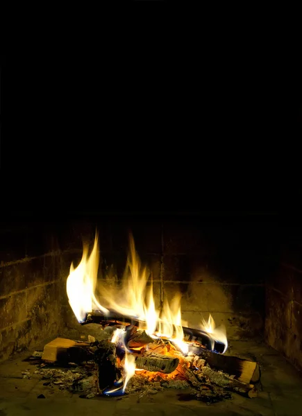 Chimney place against dark background. Flames of fire in a fireplace