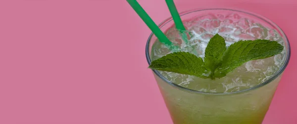 Tarragon, mint lemonade in the glass. pink background
