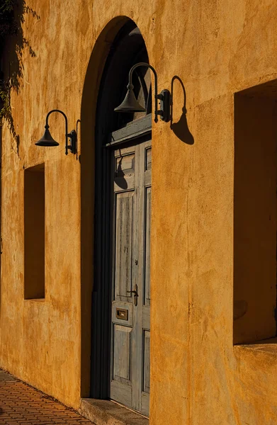 Weathered Blue Door in a Yellow Wall