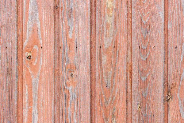 Aged wood board wall with red paint faded