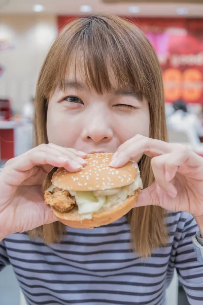 Beauty woman in cafe eating hamburger