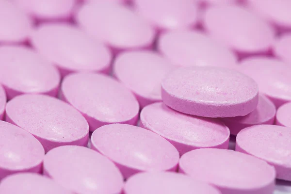 The pink tablets isolated on white background