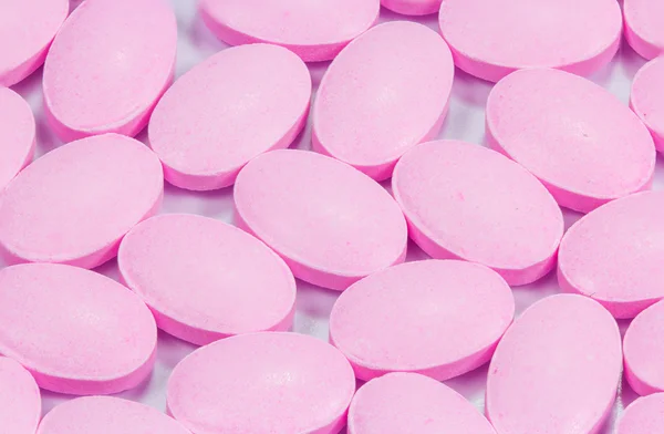 The pink tablets isolated on white background