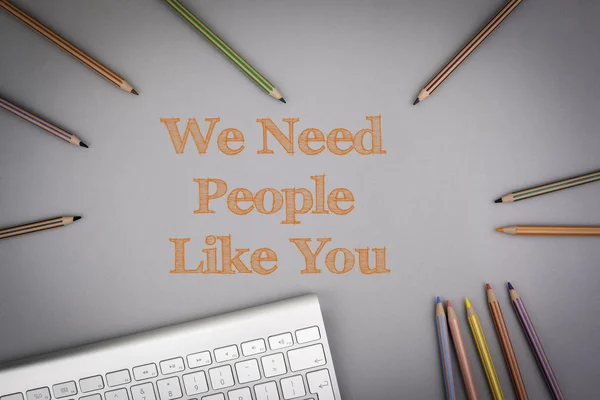 We Need People Like You. Colored pencils and a computer keyboard