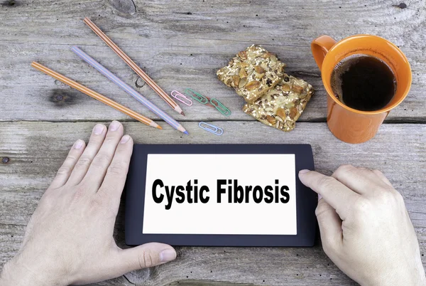 Cystic Fibrosis. Text on tablet device on a wooden tabl
