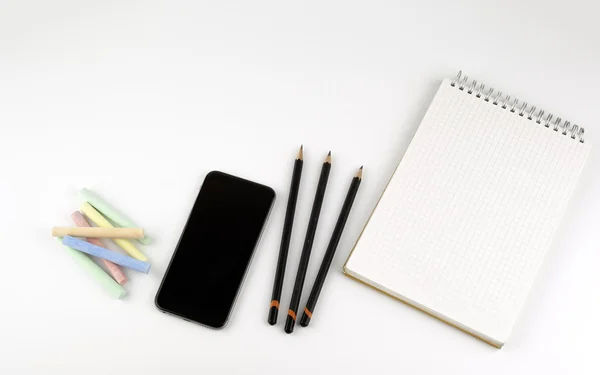 Smartphone, pencils, crayons, note pad - free space for text
