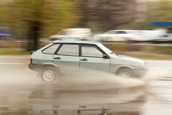 Splashes from under the wheels of a passing car through