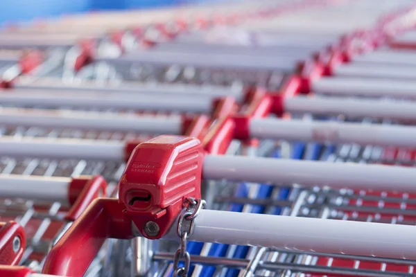 Red pen and receiver supermarket trolley coins stacked together