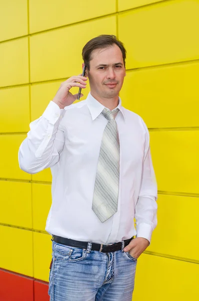 The business man in a tie speaks by phone