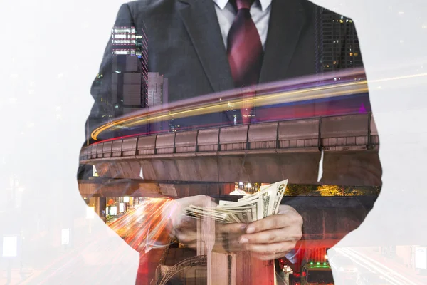 Double Exposure of Businessman in suit counting money and urban skyscrapers