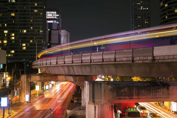 Bangkok\'s famous business landmark cityscape in busy light trails at night.