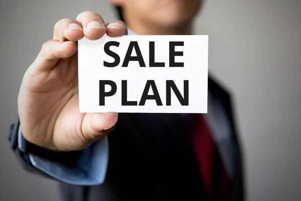 Businessman presenting 'Sale Plan' word on white card
