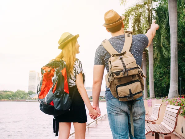Couple travelers walking and holding hands together - Journey of love and travel