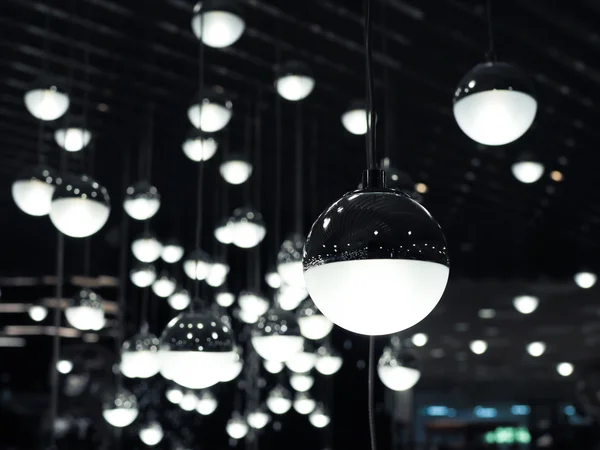 Set of white fluoescent round light bulbs hanging on decorative ceiling.