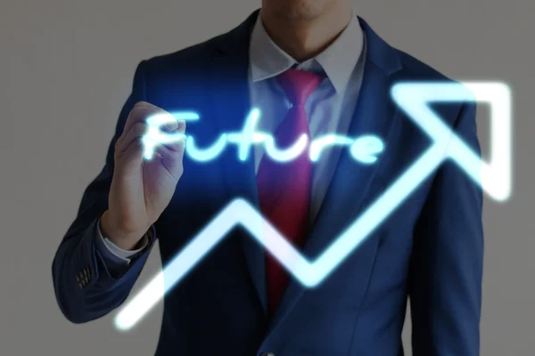 Businessman drawing FUTURE and upward graph arrows forward