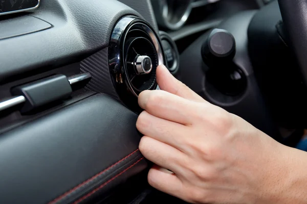 Close-up of Human hand adjusting air condition in the car