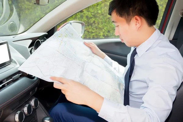 Young Asian man lost way and looking at the map to find ways out