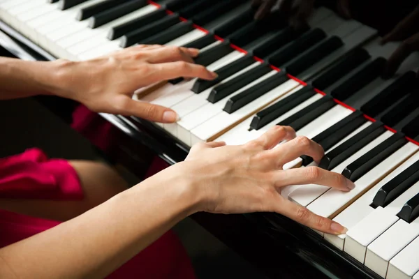Close-up of woman hands playing piano