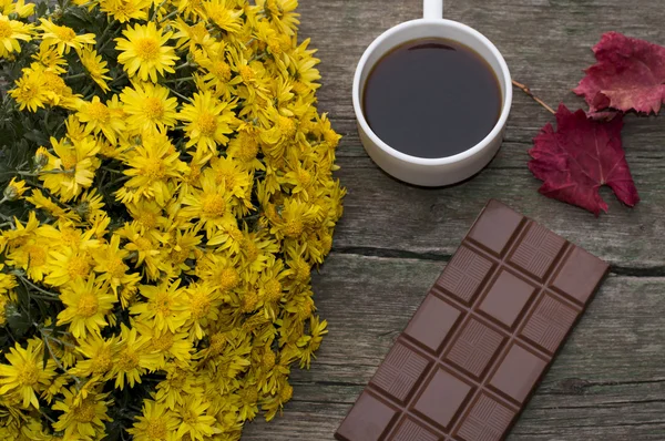 Chocolate, red leaf, bouquet of yellow flowers and coffee, on a