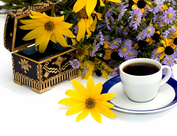 The open casket decorated yellow with flowers and coffee, isolat