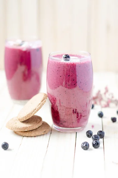 Cranberry and black currant smoothie in glass with cookies on a