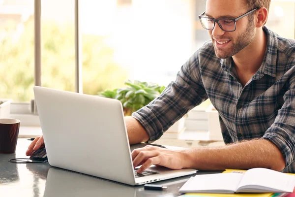 Happy man sitting and working at his desk from home