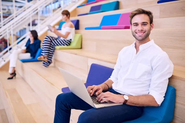 Man working on ultrabook in bright colourful co work space