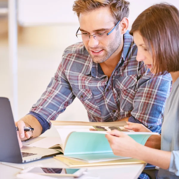 Male and female business partners busy working together