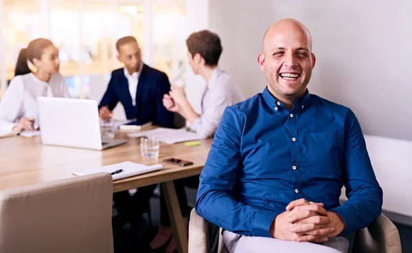 Businessman laughing in front of colleagues