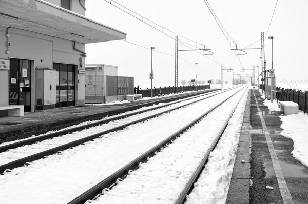 Railroad station in the country, winter landscape with snow. Black and white photo