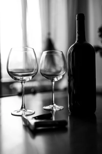 Glasses and wine bottle. Black and white photo