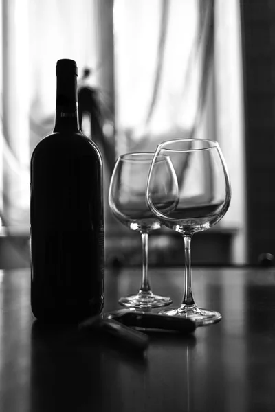 Glasses and wine bottle. Black and white photo