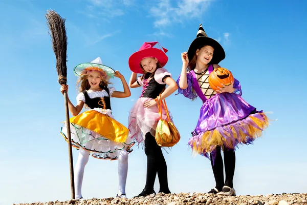 Three Cute Little Witches Standing with Bags