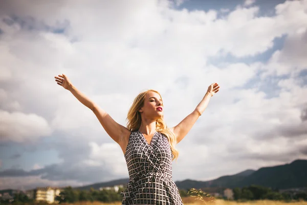 Young blonde woman arms outstretched