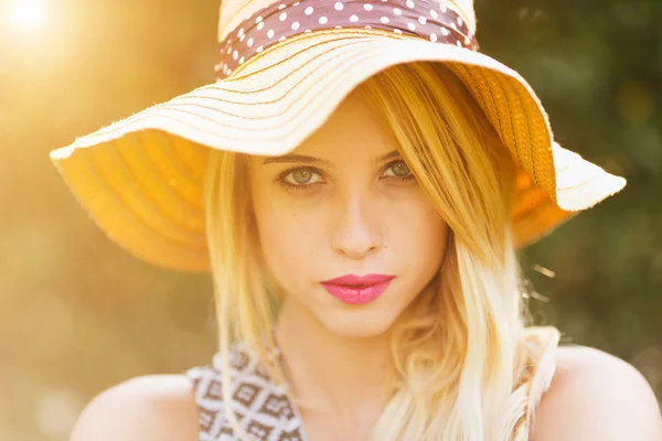 Portrait of young blonde woman with sunlight flare