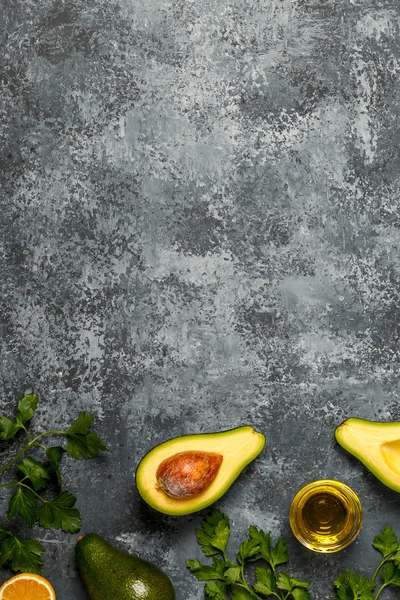 Food background with avocado, lemon, parsley and olive oil.
