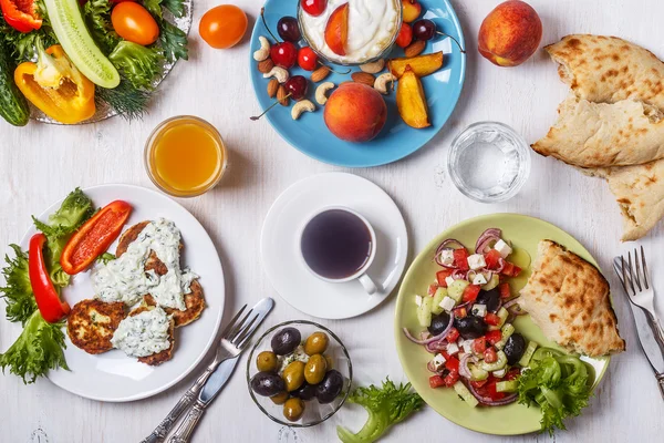 Greek appetizers  - fritters of zucchini, Greek salad, yogurt.