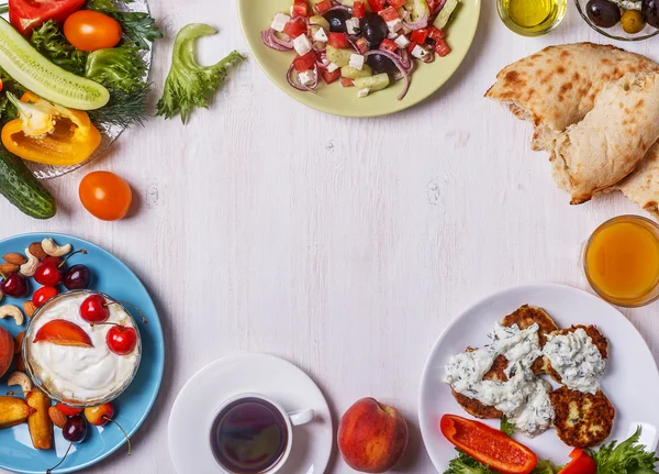 Greek appetizers  - fritters of zucchini, Greek salad, yogurt.