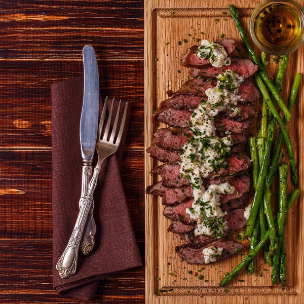 Steak with blue cheese sauce served with asparagus.