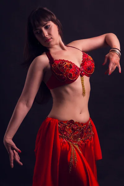 Beautiful sexy woman belly dancer. Arabian oriental professional artist in shining costume with long healthy glossy hair