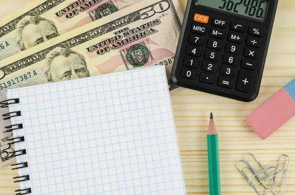 Office, business tools with dollars and calculator on wood table