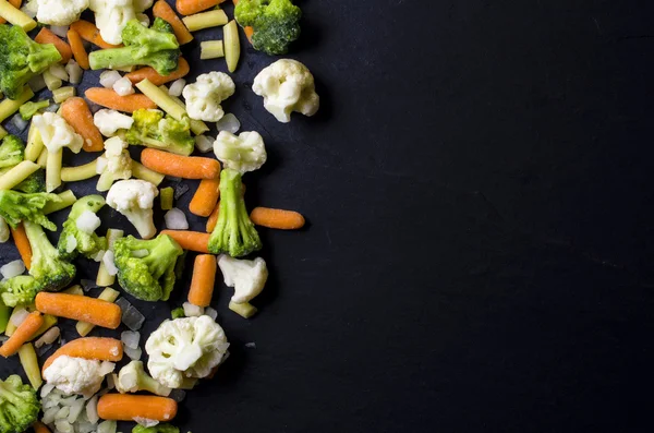 Frozen vegetables on dark table