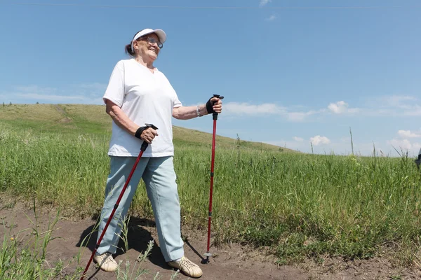 Nordic Walking - elderly woman is hiking