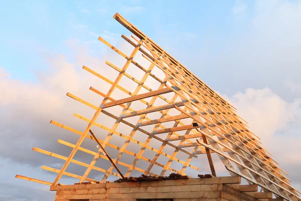 Roof of the wooden house under construction against the sky and